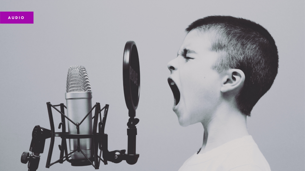 Photo of a boy yelling into a professional microphone